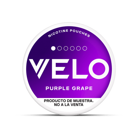 Envase redondo con una etiqueta en degradado morado en la que se lee VELO Mini Trial by VELO y bolsas de nicotina sin tabaco. El texto de la parte inferior dice Producto de muestra. No a la venta, indicando que es un producto de muestra no a la venta.