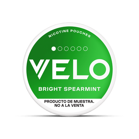 Envase circular con la etiqueta VELO Mini Trial en negrita blanca sobre fondo verde. También pone bolsas de nicotina arriba y sin tabaco, Producto de muestra. No a la venta aparece debajo.