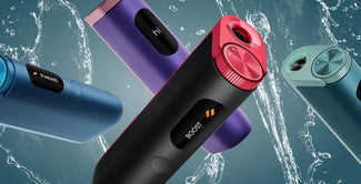 Cuatro elegantes y coloridas afeitadoras o recortadoras eléctricas con botones y pantalla digital se muestran contra un chorro de agua, resaltando su moderno diseño y su característica de resistencia al agua.