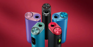 Cinco coloridos inhaladores electrónicos en posición vertical sobre fondo rojo, cada uno con una tapa metálica redonda y una pantalla o botón, dispuestos en semicírculo.