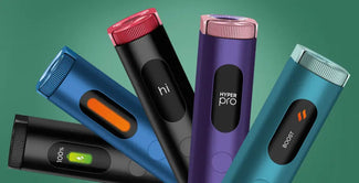 Cinco elegantes y coloridos dispositivos electrónicos de vapeo están de pie sobre un fondo verde, cada uno con una pantalla que muestra diferentes iconos, texto o niveles de batería.
