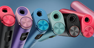 Una hilera de coloridos aparatos electrónicos con diales circulares y pantallas de visualización, mostrados en posición vertical sobre un fondo azul. Los aparatos son de color morado, azul, verde azulado, negro y rosa.