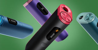 Cuatro dispositivos electrónicos cilíndricos de colores, con pantallas digitales que muestran palabras como "hi", "STANDARD" y "BOOST", aparecen flotando sobre un fondo verde. Cada uno tiene un dial texturizado en un extremo.