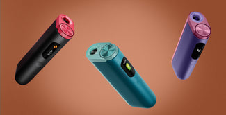 Tres elegantes y modernos inhaladores electrónicos en negro, verde azulado y morado flotan sobre un fondo marrón. Cada dispositivo tiene una parte superior circular y una pequeña pantalla digital que muestra texto o iconos.