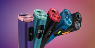 Cinco coloridos dispositivos electrónicos con tapas cilíndricas y pantallas de visualización se encuentran en posición vertical sobre un fondo degradado. Cada dispositivo presenta una combinación de colores y una etiqueta diferentes, como hi, HYPER pro y boost.