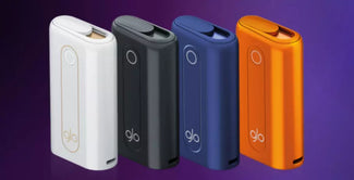 Cuatro elegantes dispositivos electrónicos rectangulares de color blanco, negro, azul y naranja se yerguen sobre un fondo morado degradado, cada uno de ellos con la etiqueta "glo" en la parte inferior.